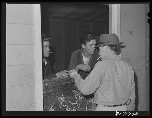 Untitled photo, possibly related to: Tulare County, California. FSA (Farm Security Administration) farm workers' camp. Exchange with man as he enters the movies