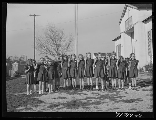 Tulare County, California. FSA (Farm Security Administration) farm workers' camp. Brownies (junior Girl Scouts) saluting the flag