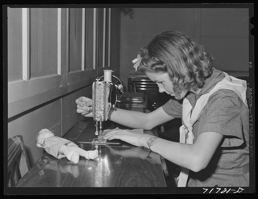 Tulare County, California. FSA (Farm Security Administration) farm workers' camp. Girl Scout learning to sew