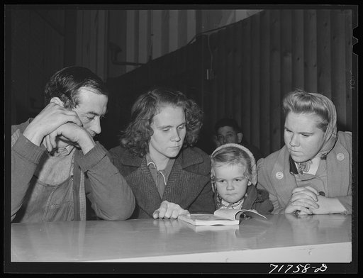 Woodville, California. FSA (Farm Security Administration) farm workers' community. Family group studying first aid lesson