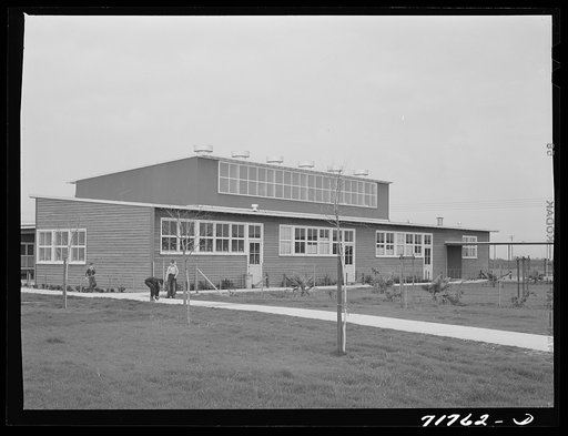 Woodville, California. FSA (Farm Security Administration) farm workers' community. Side view of the community building. Low rooms are used for school and various meetings. The higher central section is the main auditorium