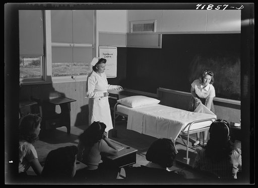 Untitled photo, possibly related to: Eleven Mile Corner, Arizona. FSA (Farm Security Administration) farm workers' community. The nurse, who divides her time between work at the hospital and NYA instruction, teaching girls who live at the NYA resident center how to make a bed properly