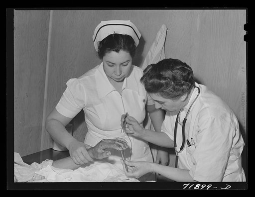 Resident doctor at the Cairns General Hospital attends boy who has been burned. FSA (Farm Security Administration) farm workers' community. Eleven Mile Corner, Arizona