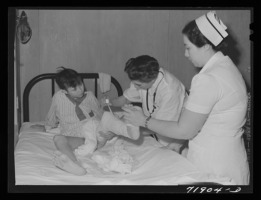 Resident doctor at the Cairns General Hospital changes dressing on boy who was badly burned. Eleven Mile Corner, Arizona