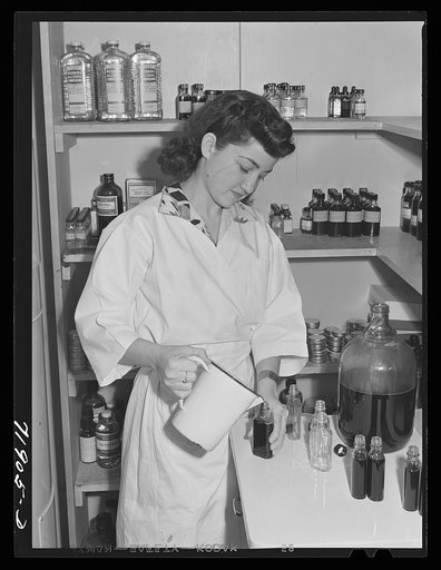 Eleven Mile Corner, Arizona. Cairns General Hospital, FSA (Farm Security Administration) farm workers' community. NYA (National Youth Administration) girl bottling medicine. The NYA girls, who live at the resident center, receive training as nurses helpers