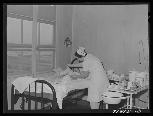 Eleven Mile Corner, Arizona. Cairns General Hospital, FSA (Farm Security Administration) farm workers' community. Nurse removing bandages from a patient
