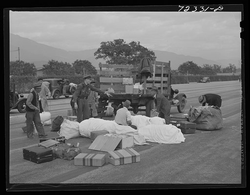Santa Anita reception center, Los Angeles County, California. The evacuation of Japanese and Japanese-Americans from West coast areas under United States Army war emergency order. Examining baggage of Japanese as they arrive