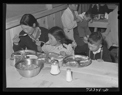 Santa Anita reception center, Los Angeles County, California. The evacuation of Japanese and Japanese-Americans from West coast areas under United States Army war emergency order. Japanese family eating their first meal at the center. All meals are served in mess halls