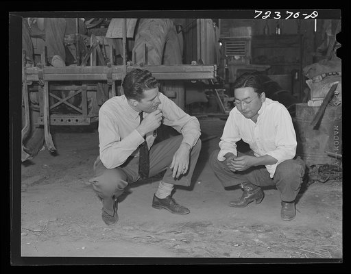 Los Angeles County, California. The evacuation of Japanese-Americans from West coast areas under United States Army war emergency order. A Japanese farmer talking with white farmer who is considering the purchase of some of his equipment