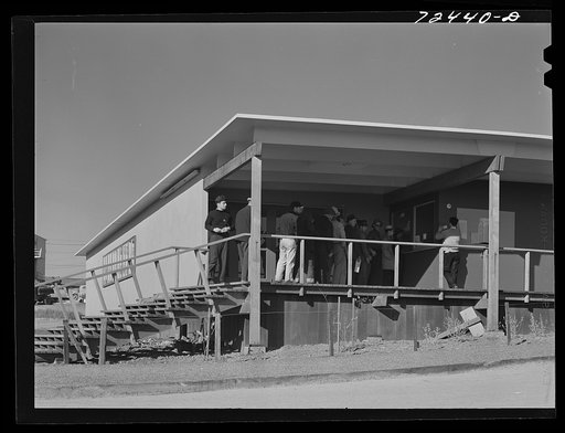 Untitled photo, possibly related to: Vallejo, California. FSA (Farm Security Administration) defense housing project. Men calling for mail at the administration building