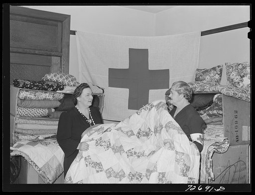 Untitled photo, possibly related to: Turlock, California. Housewife (left) with some of the quilts the PTA (Parent Teacher Association) has made for the Red Cross. She is president of PTA