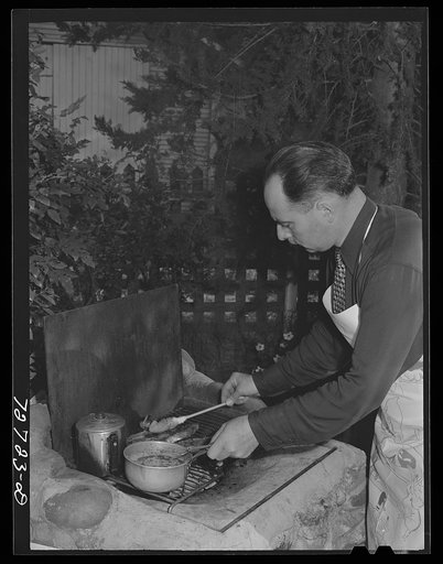 Turlock, California. Man of the house barbecues steaks over open grill in the backyard