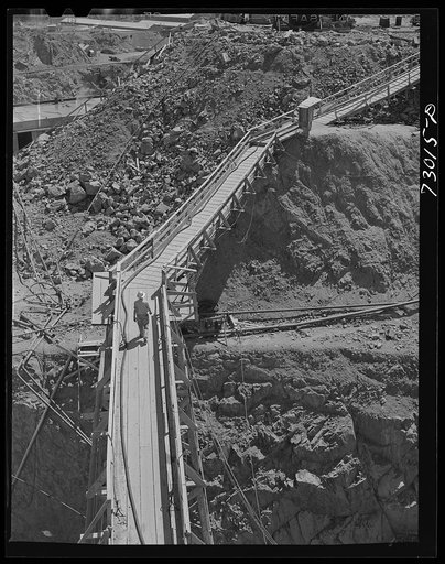 Shasta Dam, Shasta County, California. Workman crossing catwalk to construction site