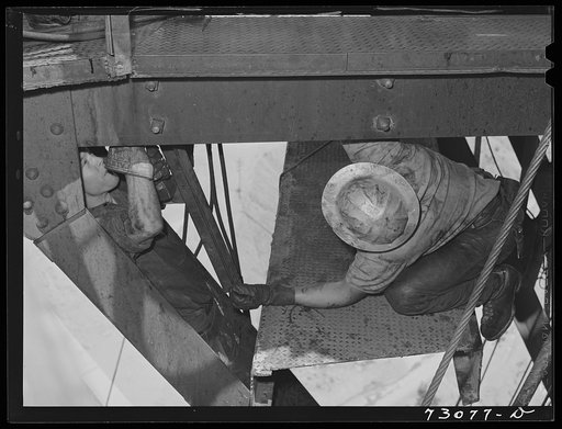Shasta Dam, Shasta County, California. Grease monkeys working in the channel irons of the head tower
