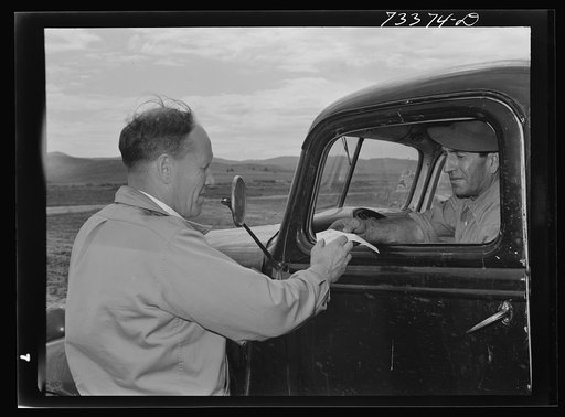 Seneca Oregon. Agent of the metal reserves company giving one of the Cox brothers, chrome ore miners, a receipt for ore delivered to the ore purchasing depot