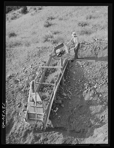 Grant County, Oregon. Miner dumping chrome ore into chute