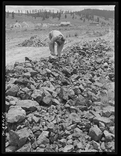 Seneca, Oregon. Agent of the metal reserves company samples specimens for assaying