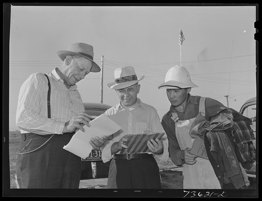 Nyssa, Oregon. FSA (Farm Security Administration) mobile camp. Sugar beet company representative left, U.S. Employment Service representative and Japanese-American worker checking a payroll
