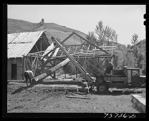Untitled photo, possibly related to: Ola, Idaho. FSA (Farm Security Administration) Ola self-help cooperative. A member places a hook on a log