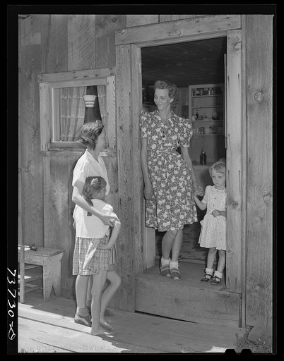 Ola, Idaho. FSA (Farm Security Administration) Ola self-help cooperative. Wife of a member talks with her visiting neighbor who is also a member of the cooperative. The mother and child standing in the doorway are the same as in photograph 21657-C taken in 1939 by Dorothea Lange. Since 1939 this fam