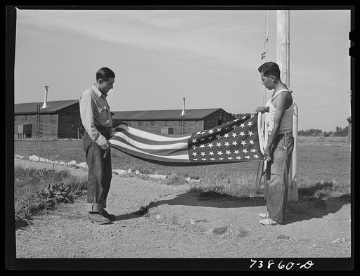 Rupert, Idaho. Former CCC (Civilian Conservation Corps) camp now under FSA (Farm Security Administration) management. Japanese-Americans taking down their flag in the evening