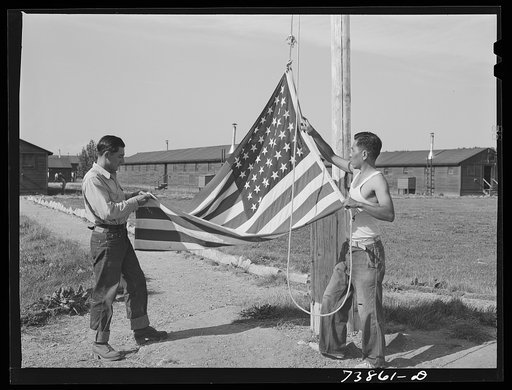 Rupert, Idaho. Former CCC (Civilian Conservation Corps) camp now under FSA (Farm Security Administration) management. Japanese-Americans taking down their flag in the evening