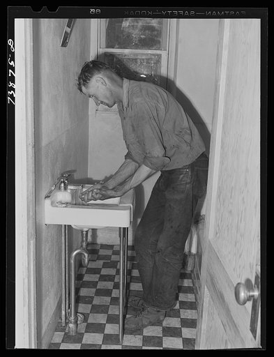 Ola, Idaho. A member of the Ola self-help cooperative in the bathroom, a recent improvement in his home of which he is proud