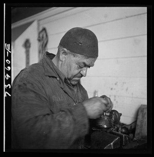 Untitled photo, possibly related to: Burley, Idaho. Mechanic in garage