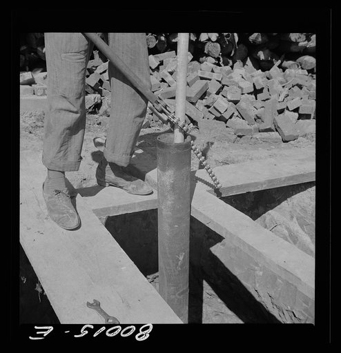 Pipe wrench is used to keep drop shaft from slipping into casing before pump is attached. John Fredrick Well project, Saint Mary's County, Maryland