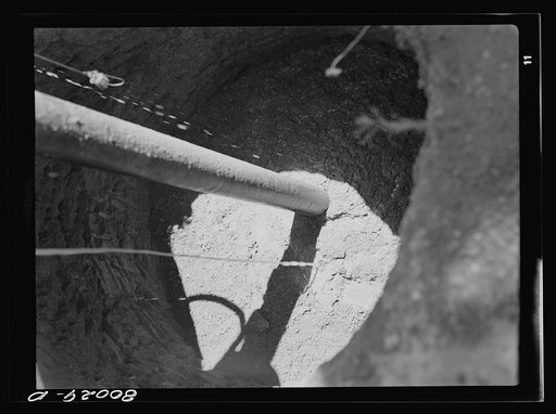 Workers have shoveled earth over cement slab and now are watering down fill to make it settle. John Fredrick well project, Charles County, Maryland, near La Plata, Maryland