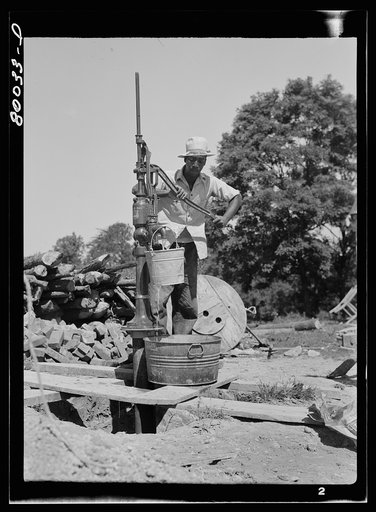 The first bucket of water is pumped. John Fredrick well project, Saint Mary's County, Maryland