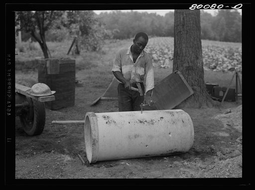 Concrete culvert pipe will replace wooden curbing. Holes are punched through to let in water. Safe well demonstration near La Plata, Maryland. Charles County
