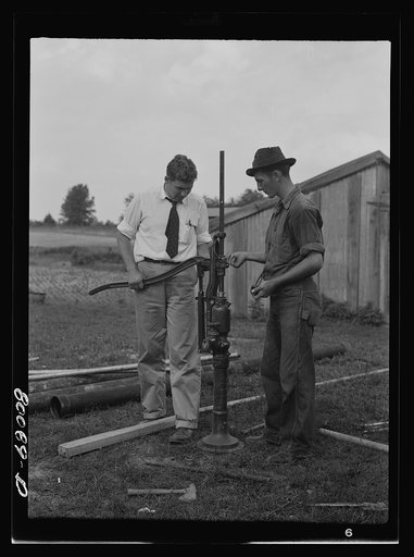 Adjusting the hand pump. Safe well demonstration near La Plata, Maryland. Charles County
