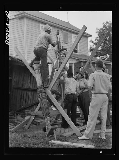 Pump is lowered on pump rod and casing before settling drop pipe in place. Long well project, Saint Mary's County, Maryland