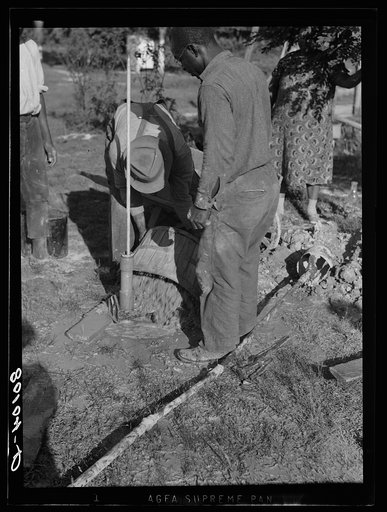 Pouring gravel around pump, Ridge well project, Saint Mary's County, Maryland