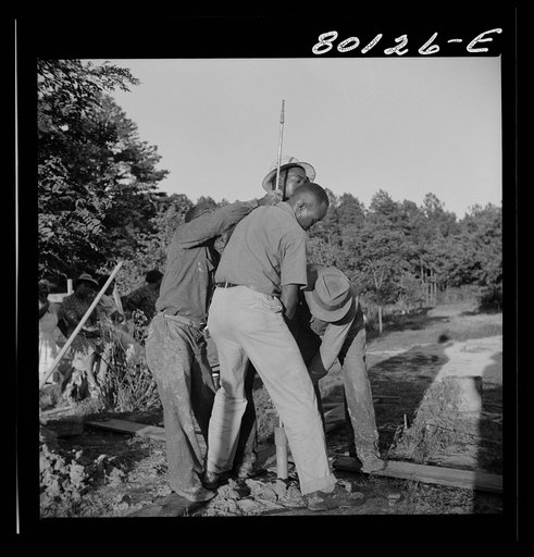 Untitled photo, possibly related to: Mr. Slater, engineer, and well crew straining on pump rod, temporarily fouled in casing. Ridge well project, Saint Mary's County, Maryland
