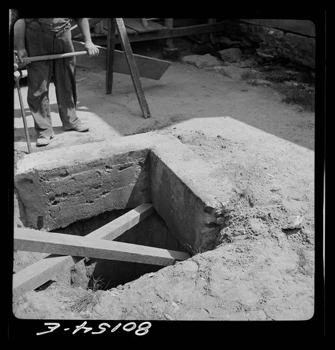 Untitled photo, possibly related to: Lifting up old cement well top prior to cleaning and installing pump. Charles County, Maryland