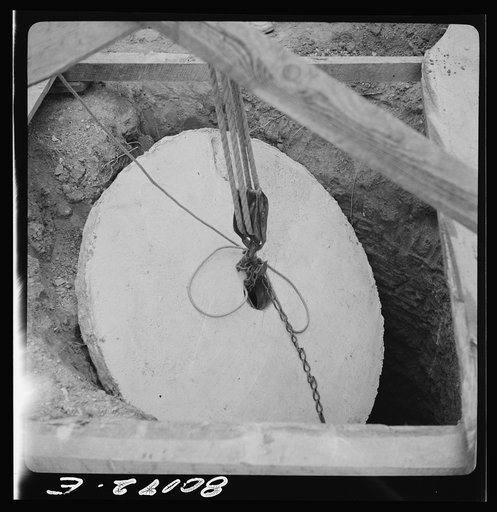Block and tackle hung from windlass serve as a rig to lower cement cap into place. John Hardesty well project, Charles County, Maryland