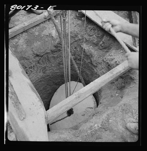 Untitled photo, possibly related to: Block and tackle hung from windlass serve as a rig to lower cement cap into place. John Hardesty well project, Charles County, Maryland