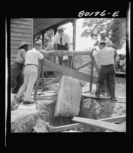 All hands are needed to lift this 300 pound block from old well top. John Hardesty well project, Charles County, Maryland