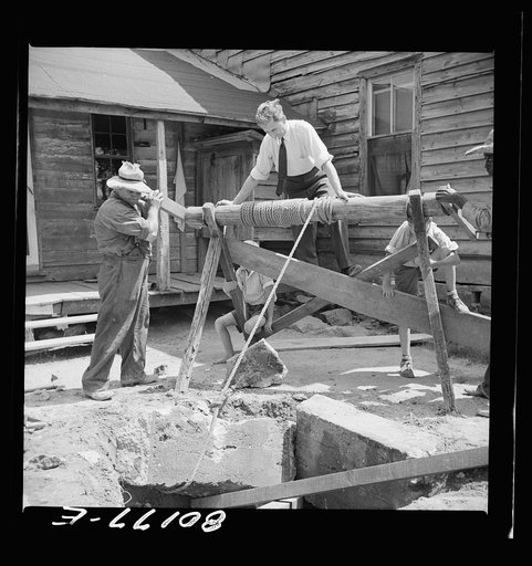Supervisor stands on windlass to ballast it from toppling into well. John Hardesty well project, Charles County, Maryland