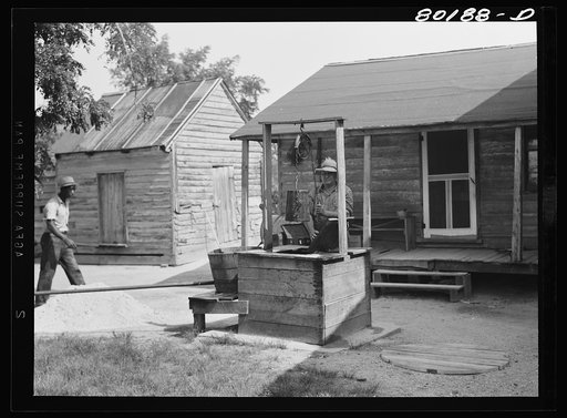 Untitled photo, possibly related to: Mr. John Hardesty draws himself a bucket of water from old well before repairs. John Hardesty well project, Charles County, Maryland