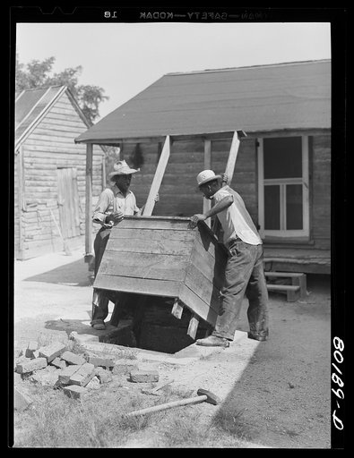 Removing the old wooden box from the top. Safe well demonstration near La Plata, Maryland. Charles County