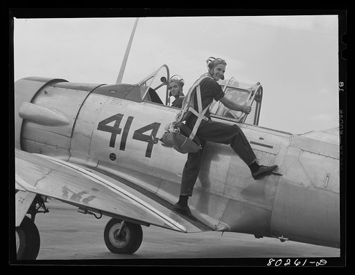 After a hearty meal of chicken, cadets R.J. Neal and G.D. Mabds climb into their pursuit plane, ready to take off. Craig Field, Southeastern Air Training Center, Selma, Alabama