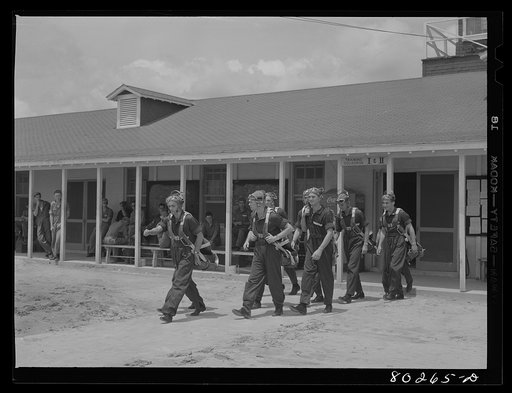 Cadets leave lockers for the field still smiling over their hearty meal of fried chicken supplied through the "Food for Defense" program. Craig Field, Southeastern Air Training Center. Selma, Alabama