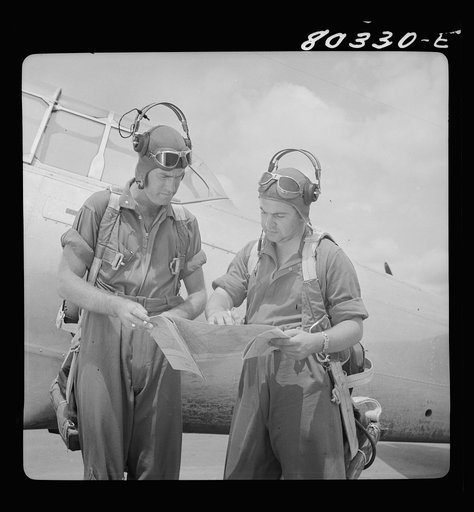 Flight instructors E.E. McTaggart and J.C. Gumison chart the day's flight. Craig Field, Southeastern Air Training Center, Selma, Alabama