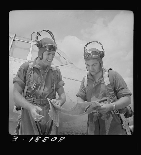 Flight instructors E.E. McTaggart and J.C. Gumison chart the day's flight. Craig Field, Southeastern Air Training Center, Selma, Alabama