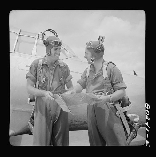 Flight instructors McTaggart and Gumison chart the afternoon flight after fried chicken dinner. Craig Field, Southeastern Air Training Center, Selma, Alabama