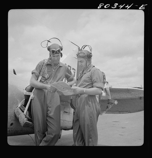 Flight instructors McTaggart and Gumison chart the afternoon flight after dinner of fried chicken. Craig Field, Southeastern Air Training Center, Alabama