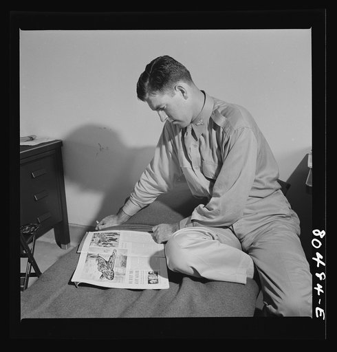 Flight instructior McTaggart takes things easy after satisfying meal of fried chicken raised by FSA (Farm Security Administration) borrowers. Craig Field, Southeastern Air Training Center. Selma, Alabama